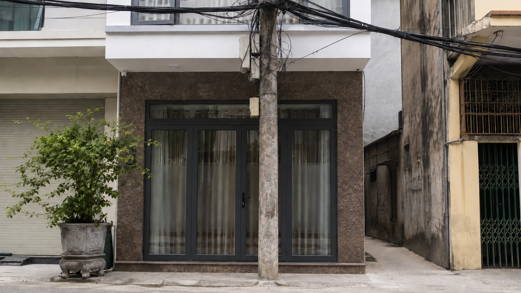 Cột điện đứng chắn mặt tiền trước một ngôi nhà tại Hà Nội